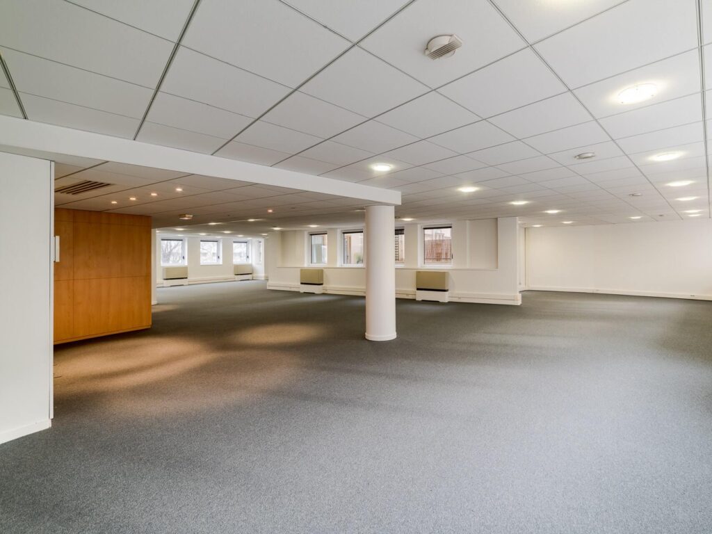 empty open office area with grey carpeting