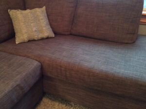 brown sectional couch with pillow