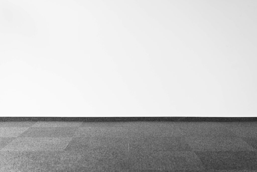 grey carpet tiles in front of white wall