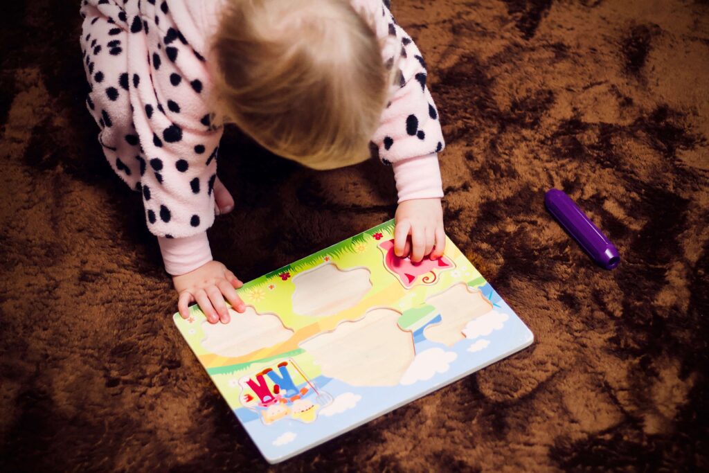 baby playing game on brown carpet floor