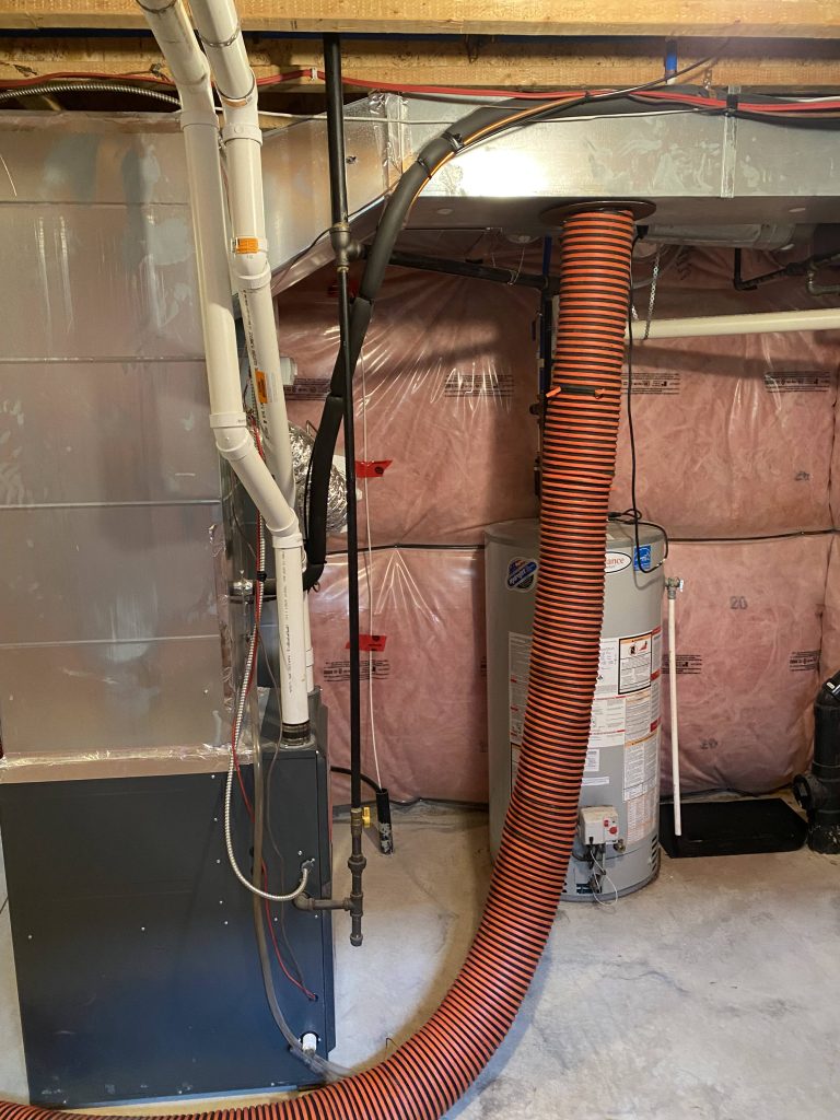 duct cleaning hose attached near furnace