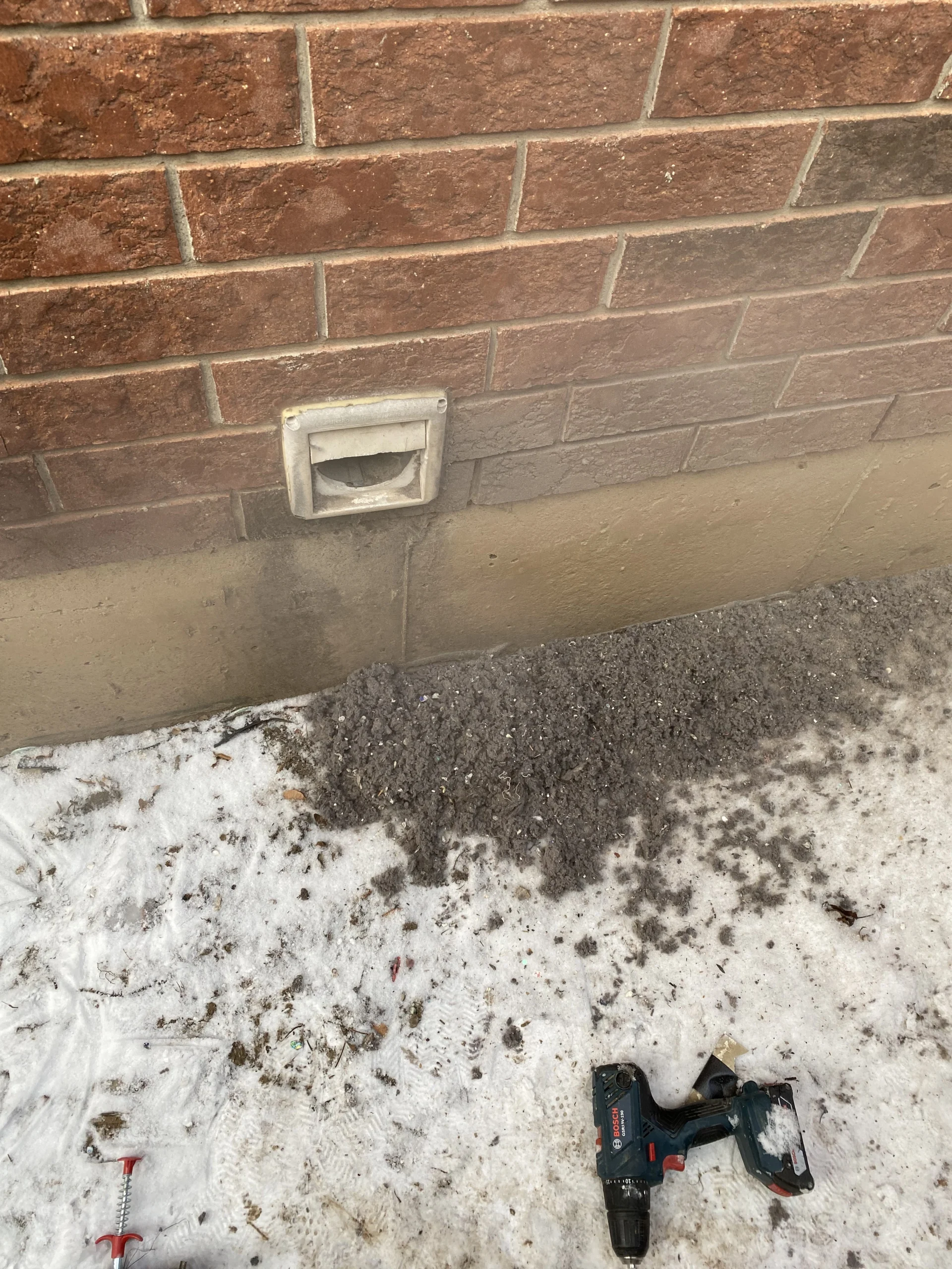 dryer vent exhaust on side of house with lots of removed lint