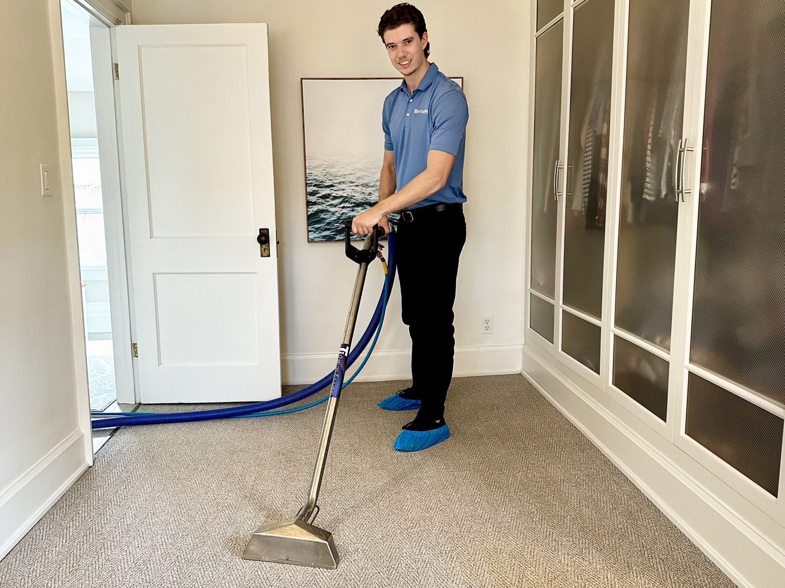 smiling technician in blue shirt holding cleaning wand